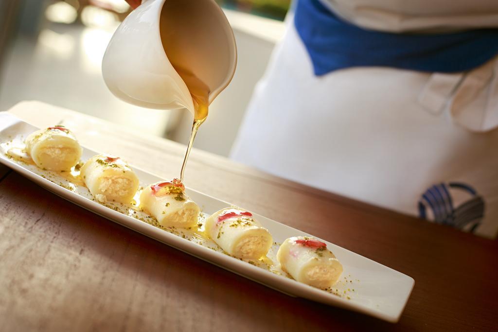Khalidiya Palace Rayhaan By Rotana, Abu Dhabi Esterno foto A sauce being drizzled onto a dish